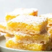lemon bars stacked on a green cake stand.