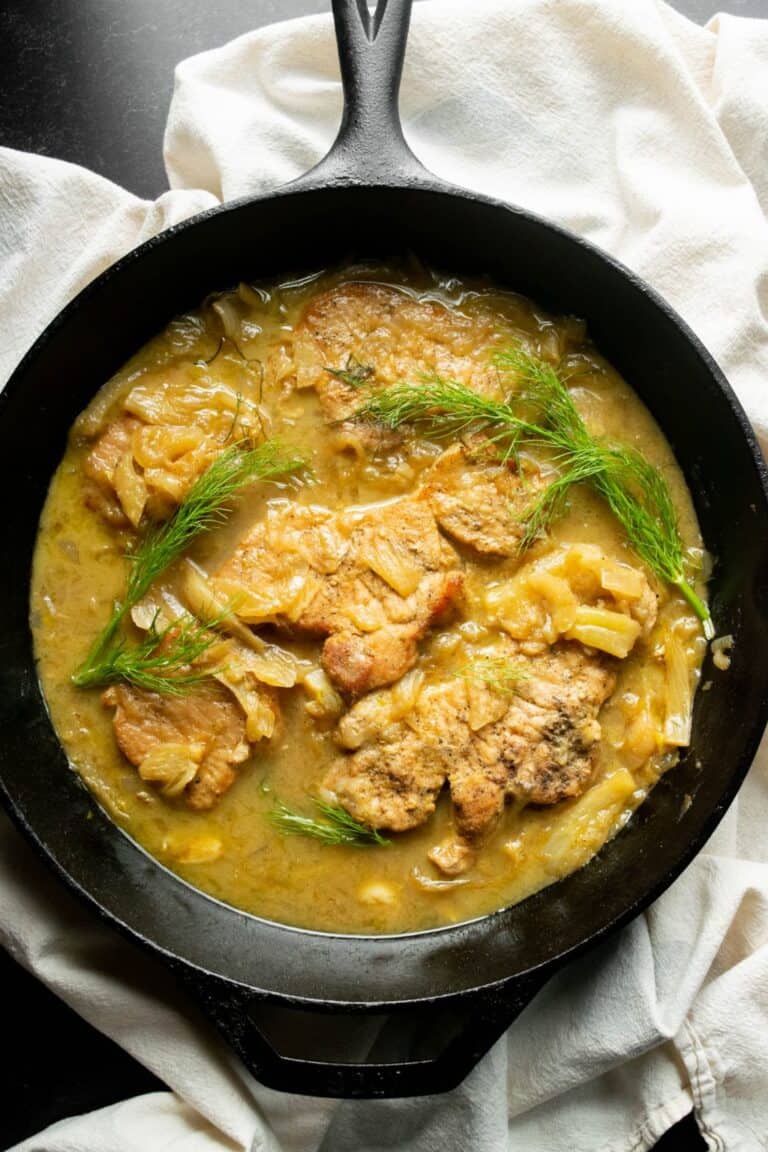 pork chops in a skillet in fennel dijon sauce.