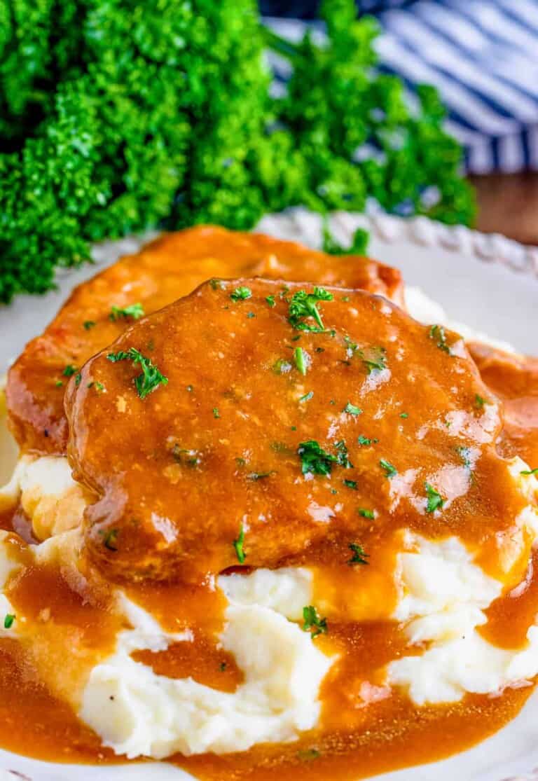 pork chops with sauce over mashed potatoes.