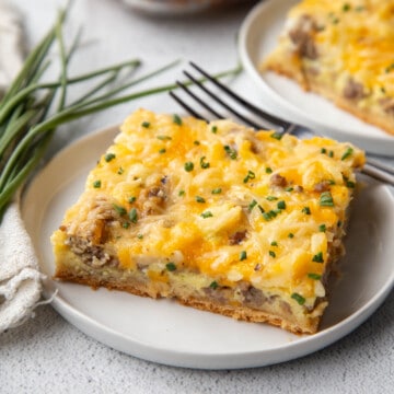 slice of sausage breakfast pizza on a white plate.