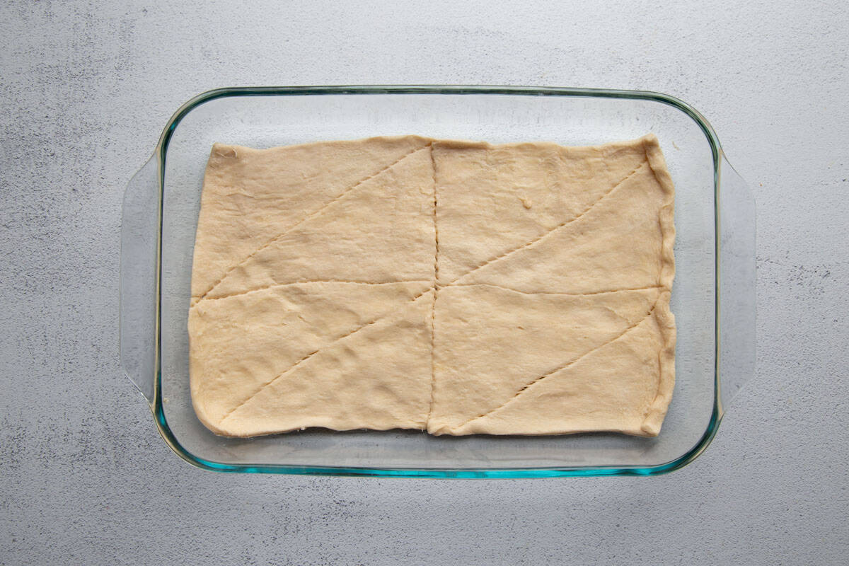 unbaked crescent rolls in a single layer in a glass dish.