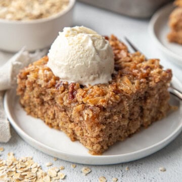 slice of old fashioned oatmeal cake with a scoop of vanilla ice cream on top.
