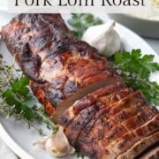 sliced marinated pork roast on a white platter.