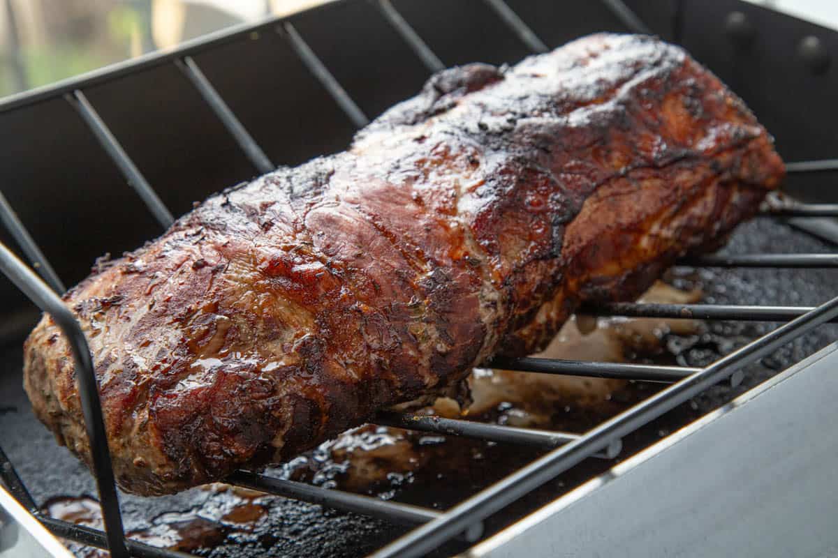 cooked pork loin roast on a roasting rack.