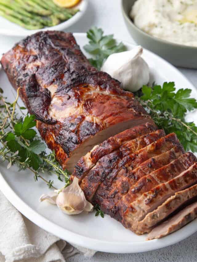 marinated pork loin roast sliced on a platter.
