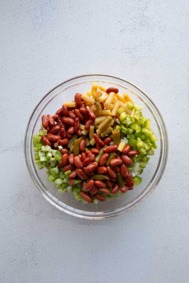 dry ingredients for three bean salad in a glass mixing bowl.