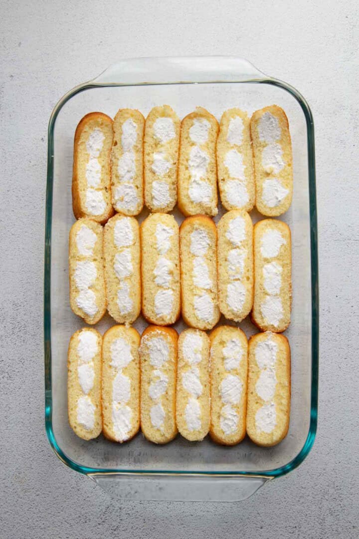 rows of twinkies cut in half in a glass dish.