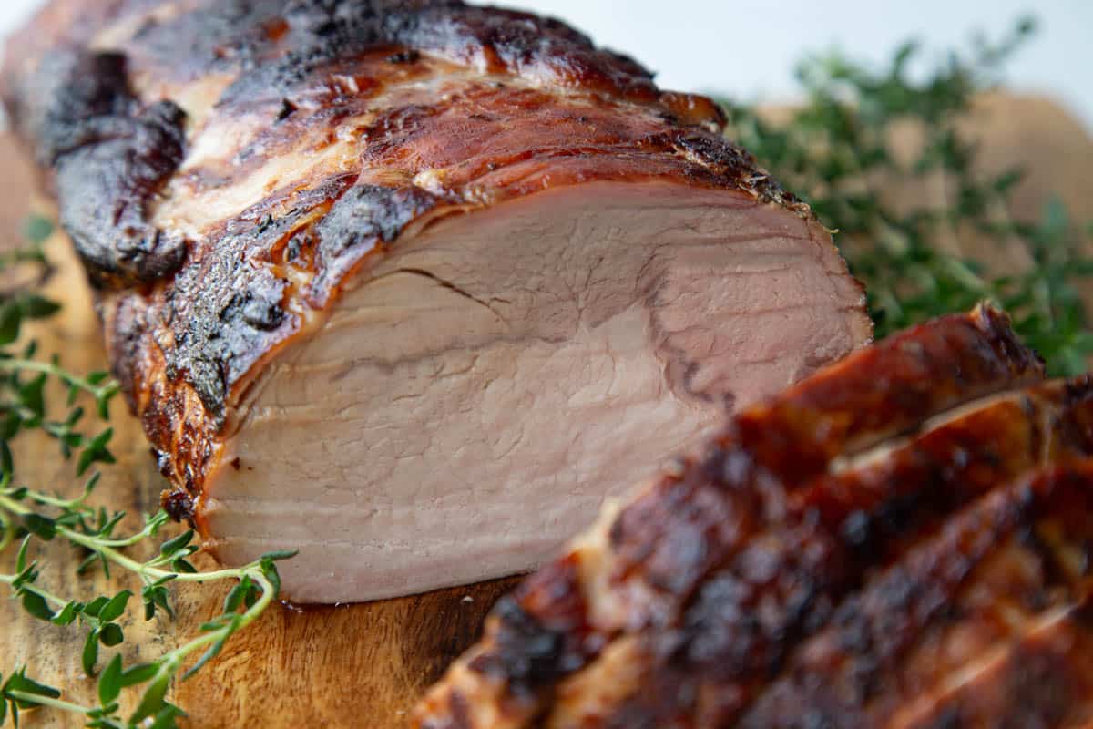 sliced pork loin roast on a wooden board.
