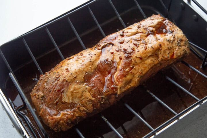 raw pork roast on a roasting rack.