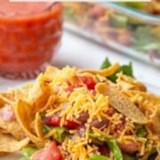 taco salad with cheese and beans and fritos.