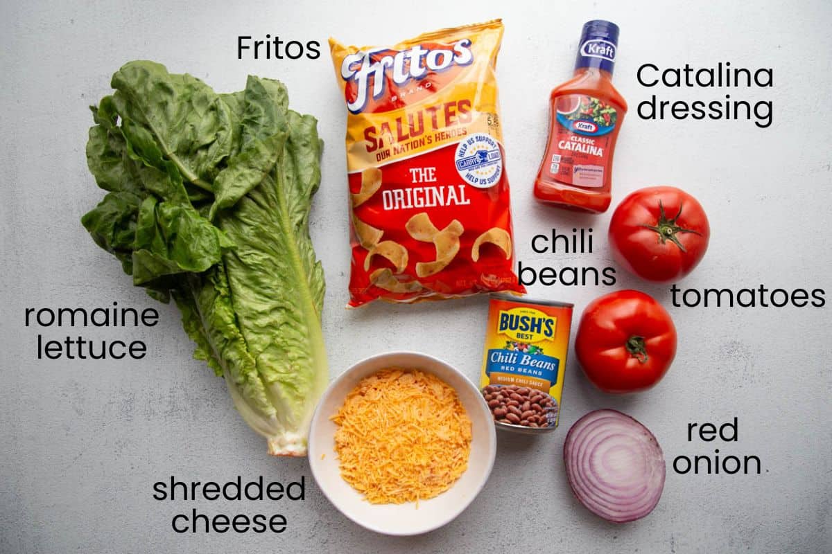 lettuce, fritos, tomatoes, and other ingredients.