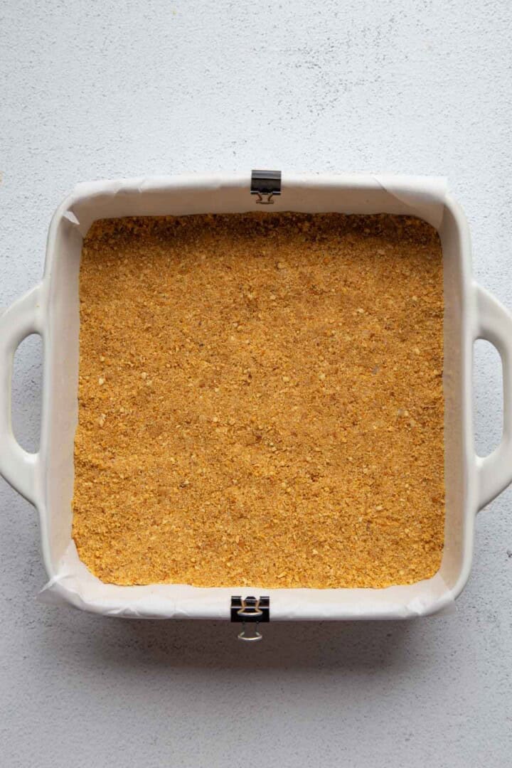 graham cracker crust packed into a dish.