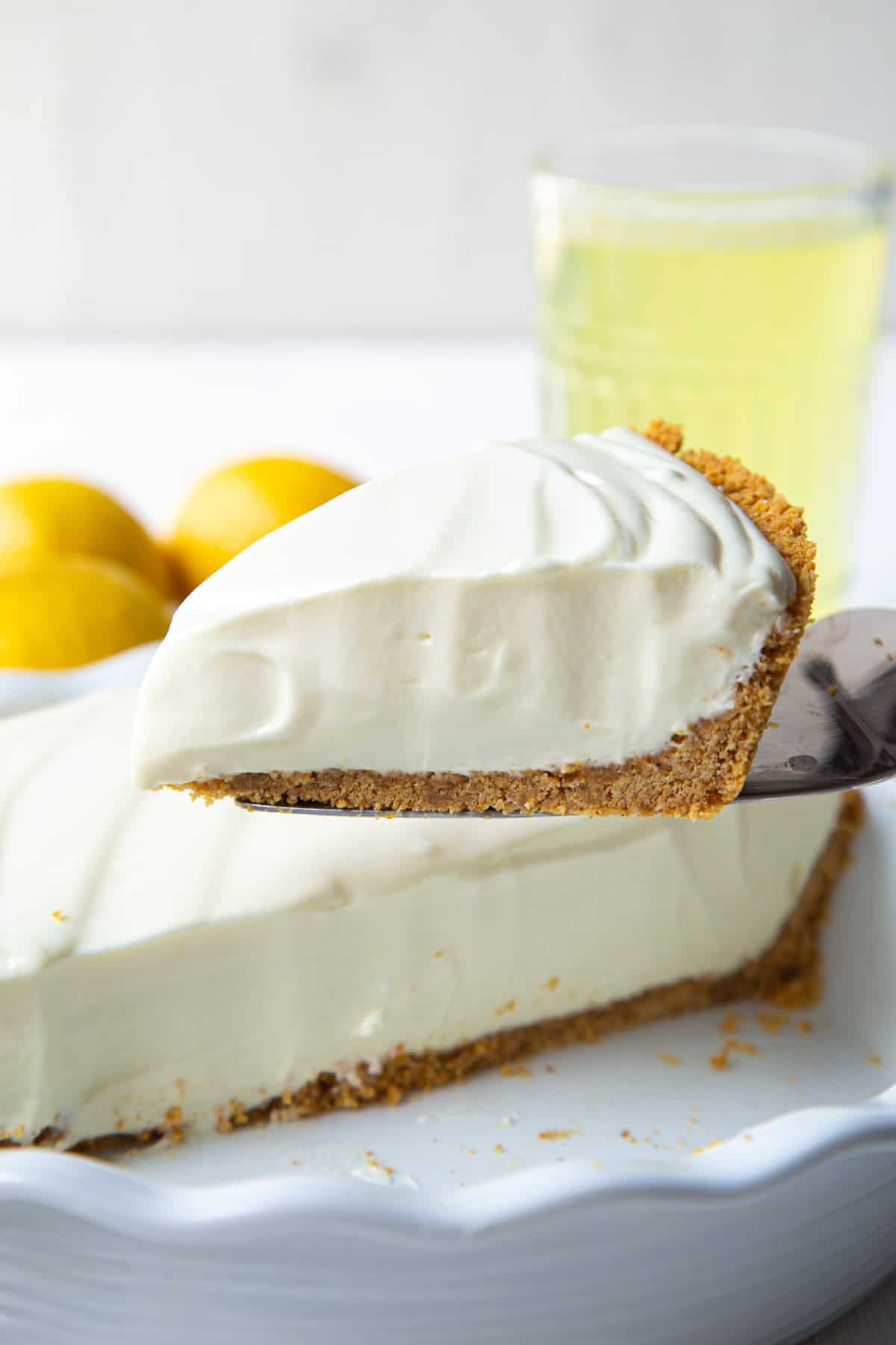 slice of lemonade pie being lifted from a whole pie.