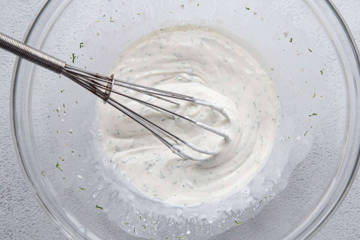 sour cream mixture in a glass bowl with a whisk.