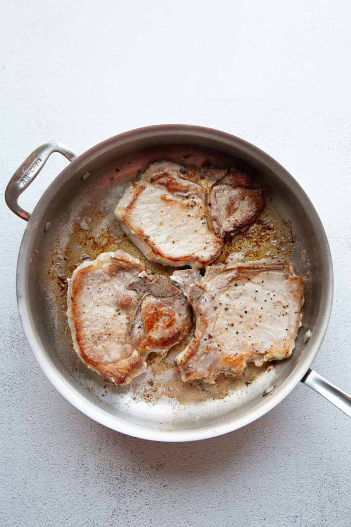 cooked pork chops in a skillet.