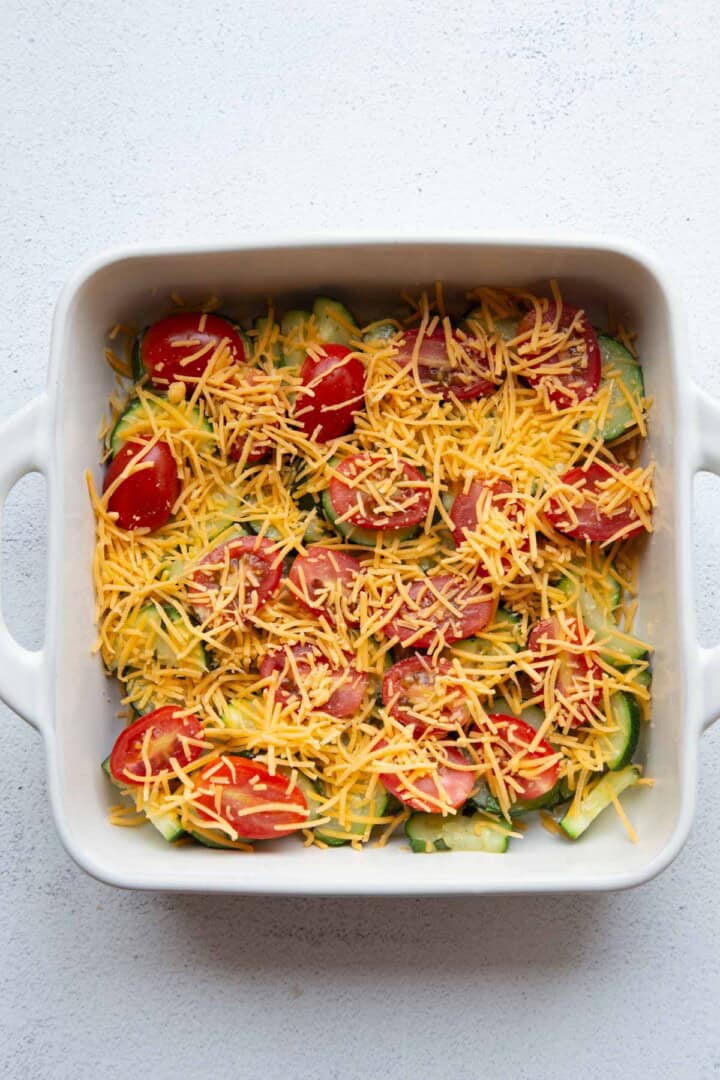 zucchini, tomatoes, and cheese in a dish.