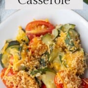 zucchini and tomatoes with breadcrumbs and cheese on top.