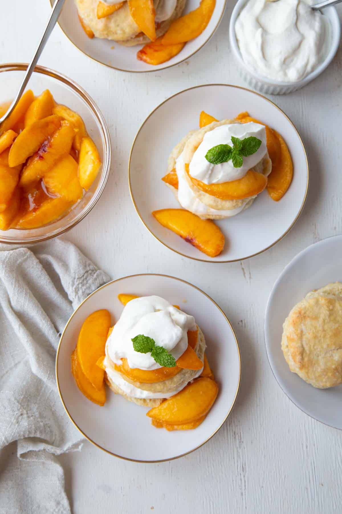 saucers with peach shortcake and whipped cream.