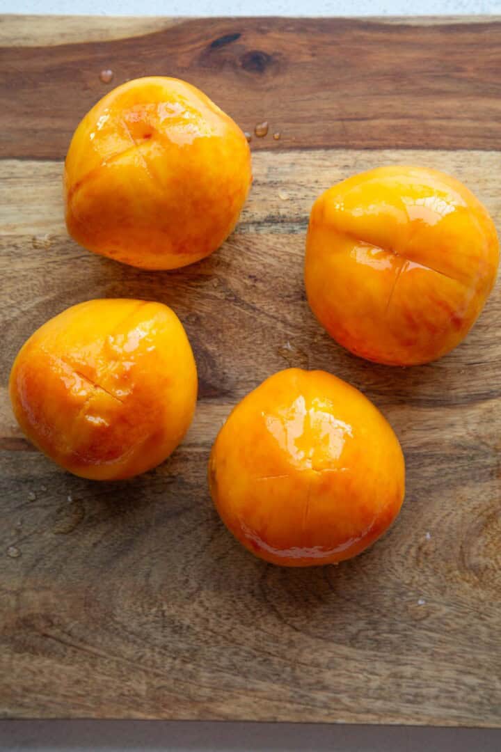 peeled peaches on a cutting board.