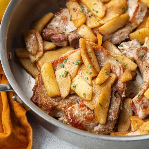 pork chops and apples in a skillet.