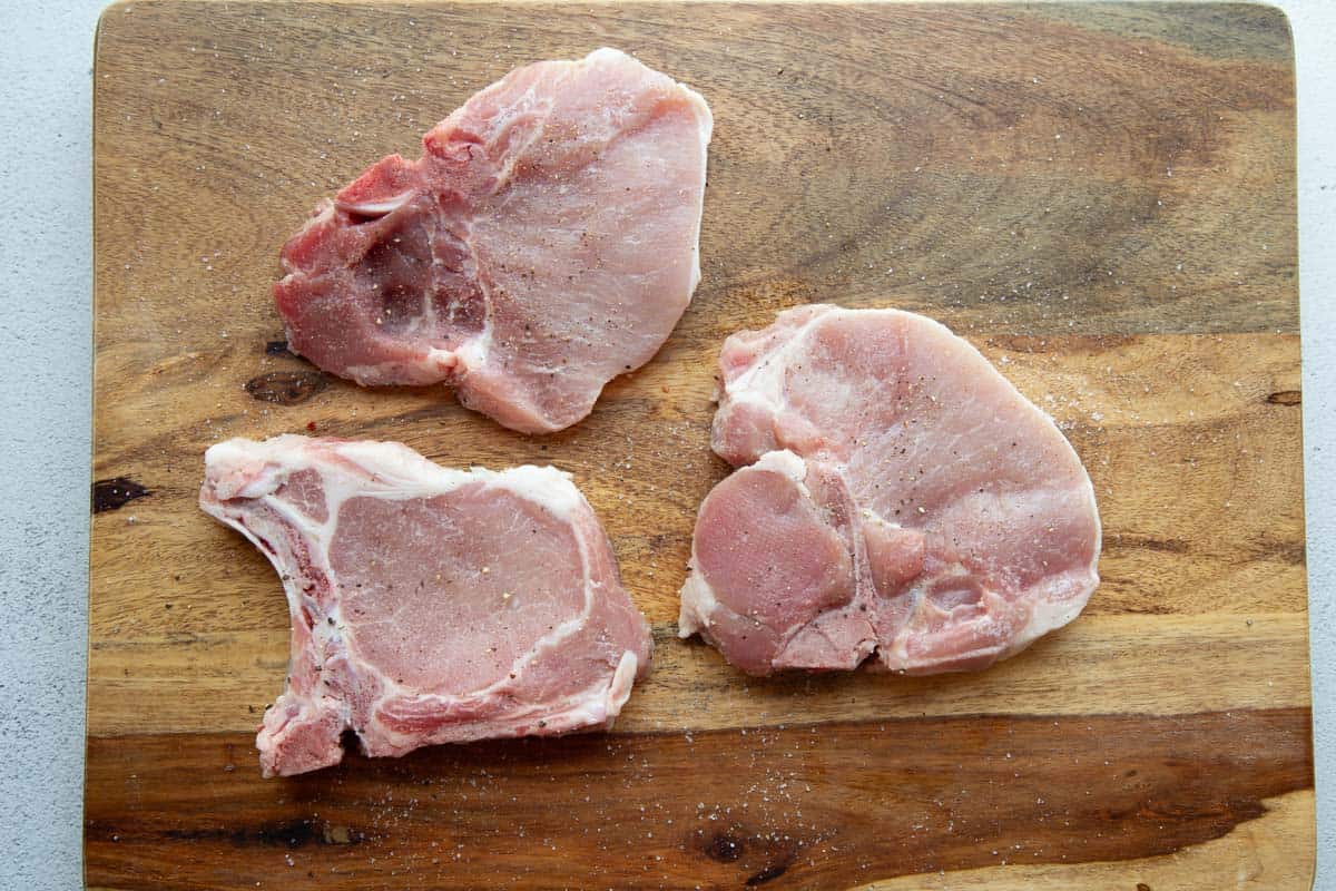 raw pork chops with salt and pepper.