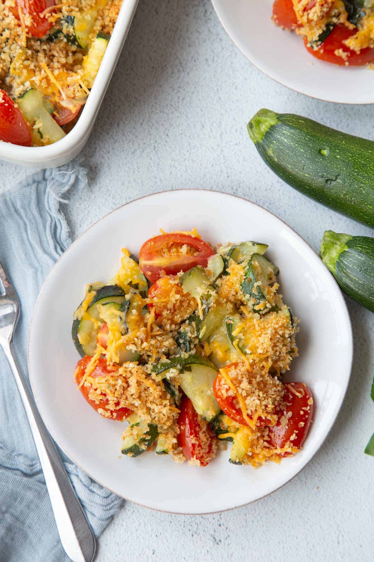 zucchini tomato casserole on a white plate.
