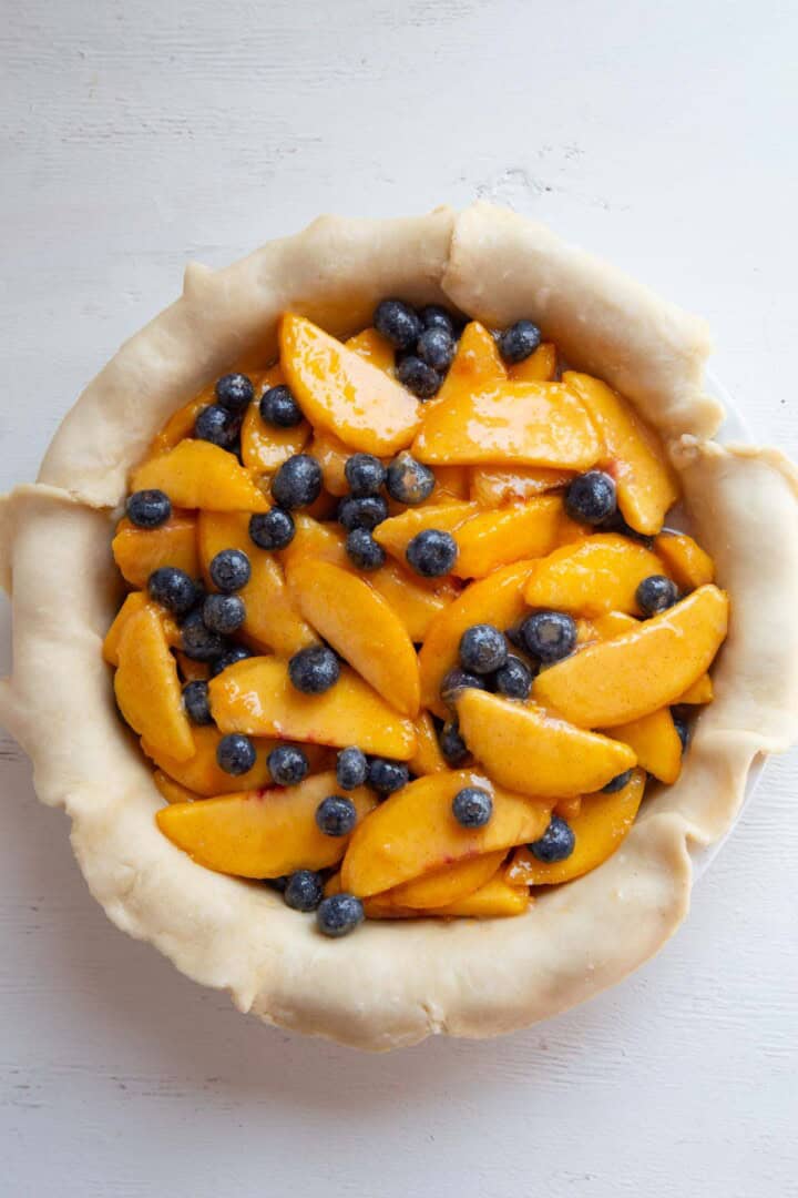 peaches and blueberries in pie crust.