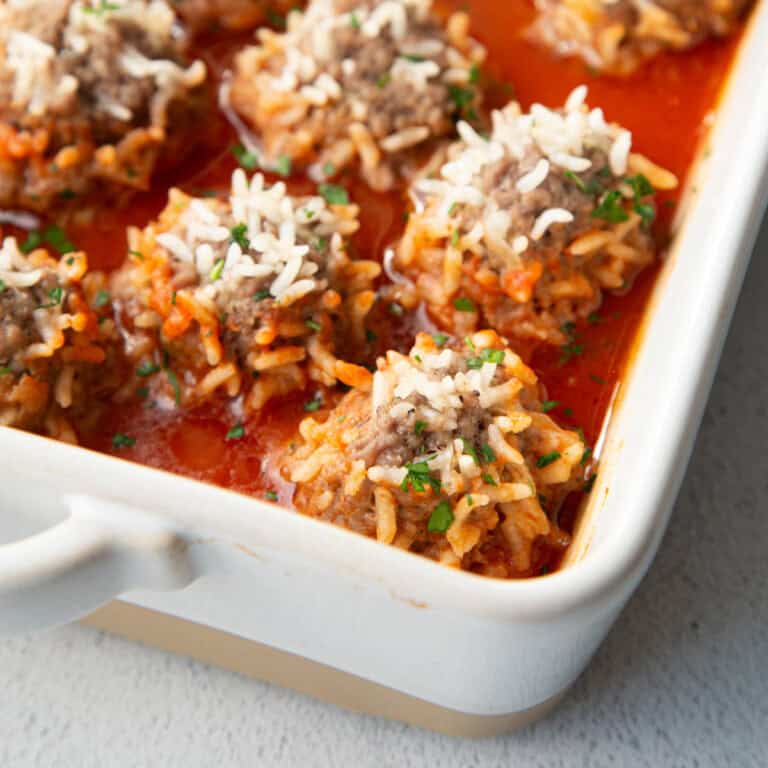 porcupine meatballs in a white casserole dish.