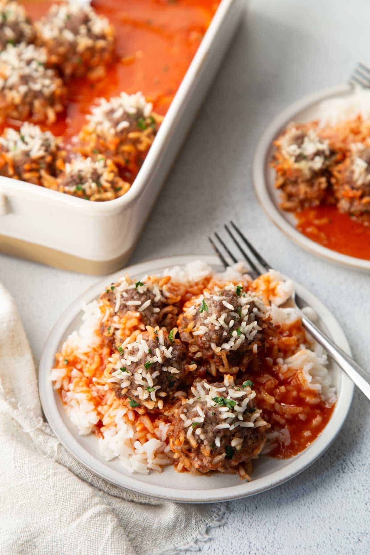 old fashioned porcupine meatballs over rice on a white plate.