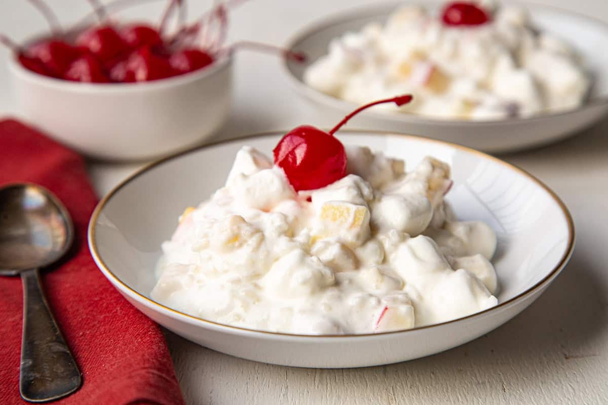 small dish of glorified rice with a maraschino cherry.