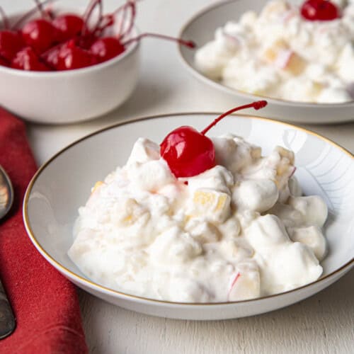 glorified rice in a shallow dish topped with a maraschino cherry.