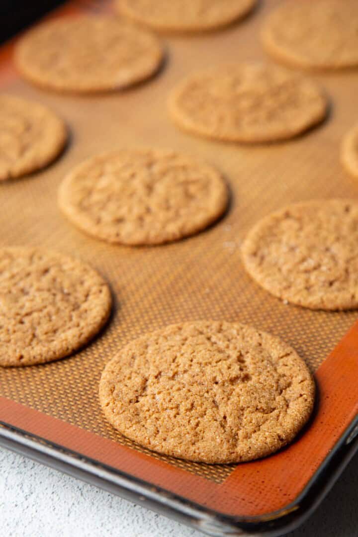 baked gingersnaps on a baking mat.