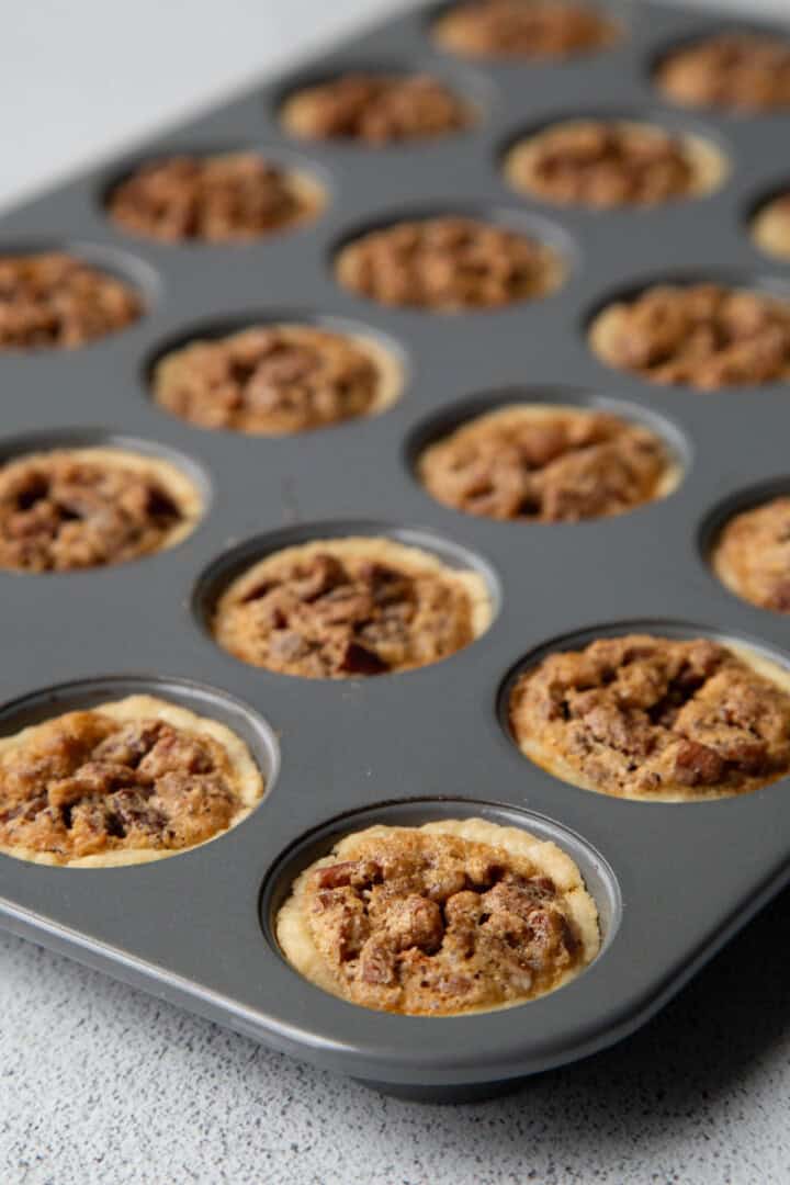 baked pecan tassies in a mini muffin tin. 