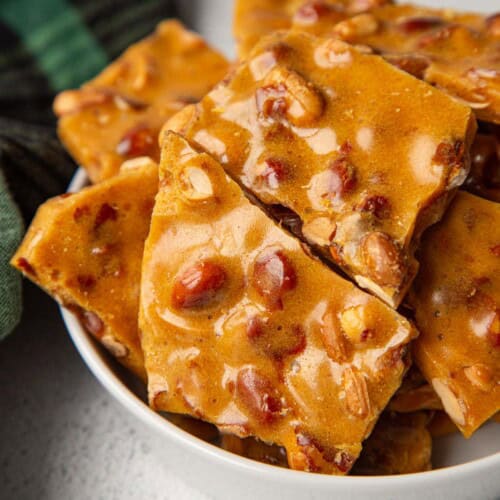 old fashioned peanut brittle in a white dish.