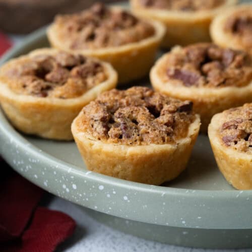 pecan tassies on a green pedestal platter.