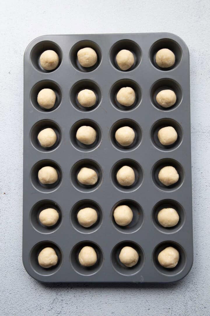 balls of dough in a mini muffin tin.