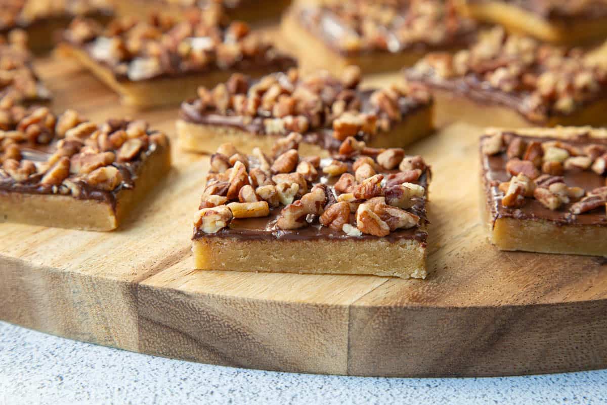 chocolate toffee squares on a wooden board.