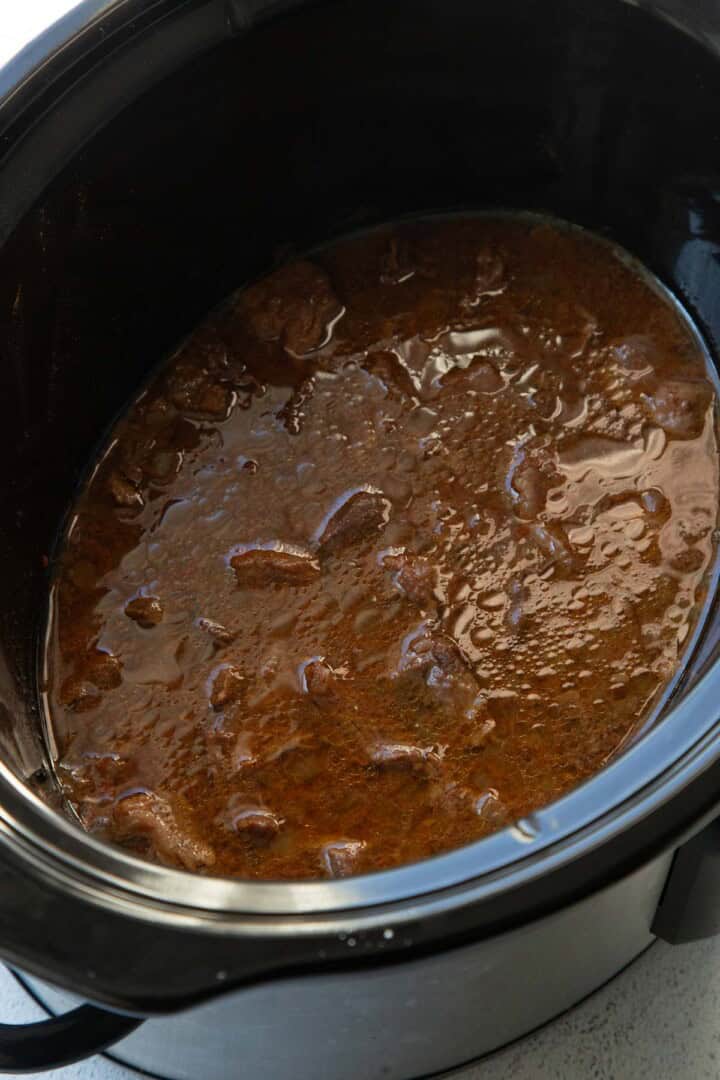 cooked beef in a paprika sauce in a crockpot.