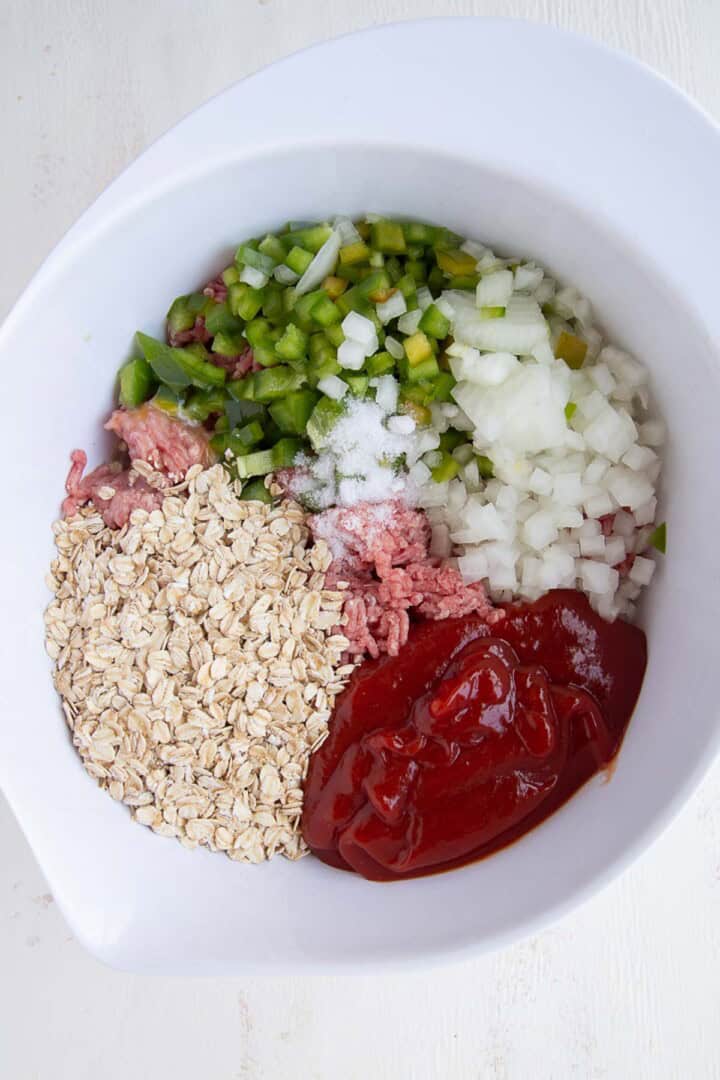 oats, ground beef, ketchup in a white bowl.
