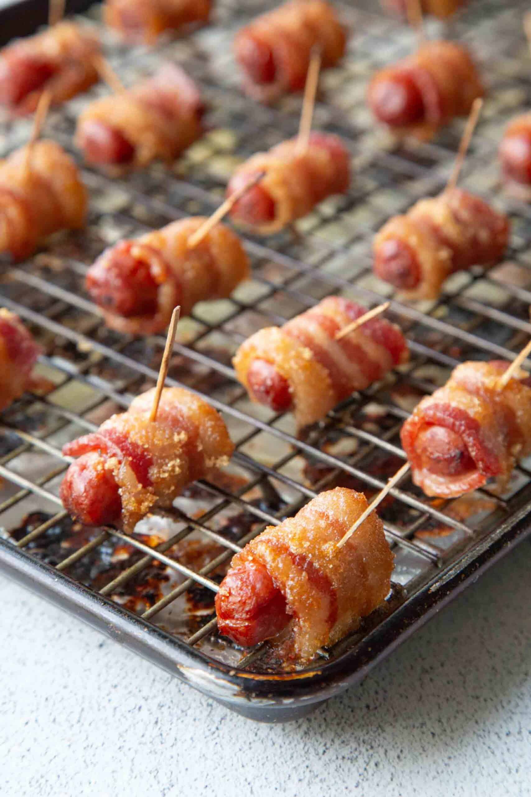 bacon wrapped smokies on a wire rack.