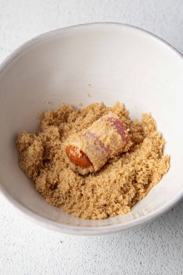 bacon wrapped smoky in a bowl of brown sugar.