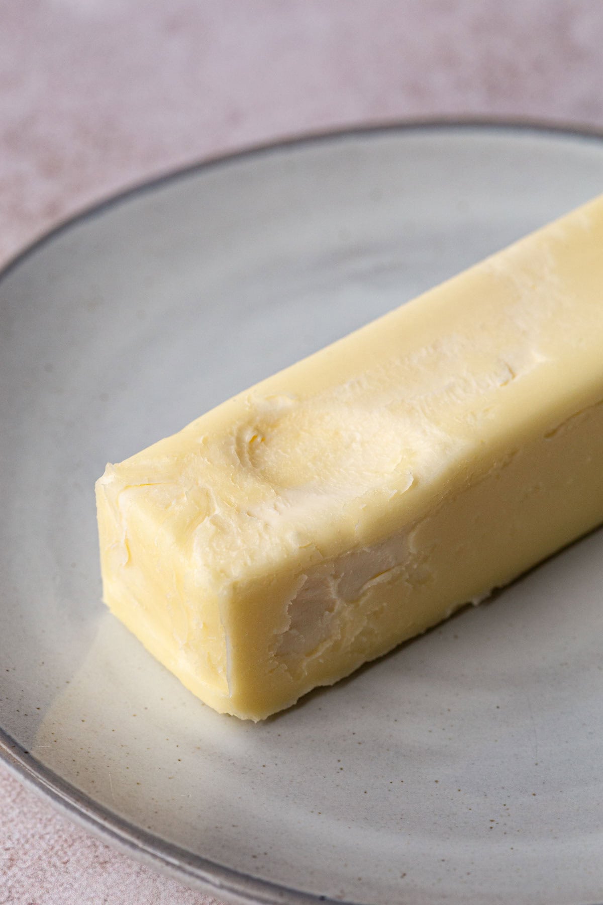 stick of butter with a fingerprint showing that it's softened.