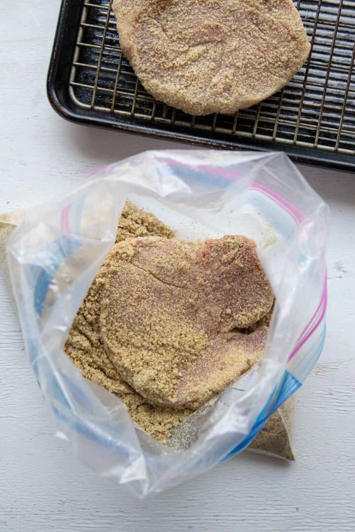 pork chop inside a plastic bag with seasoning.