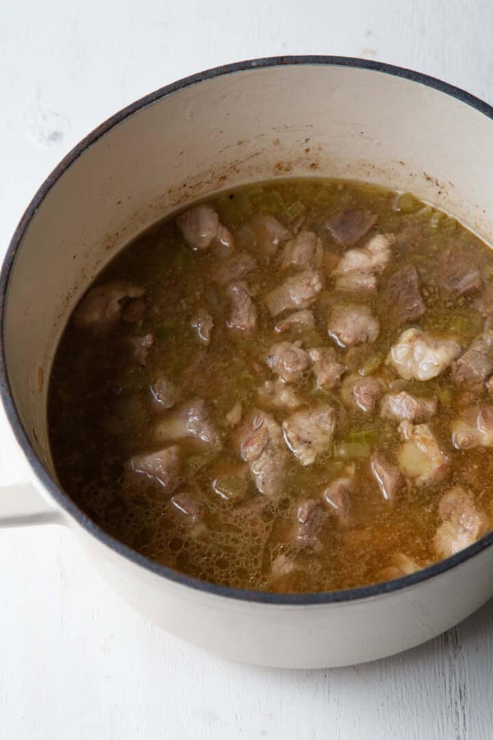 cooked beef and pork in a dutch oven.