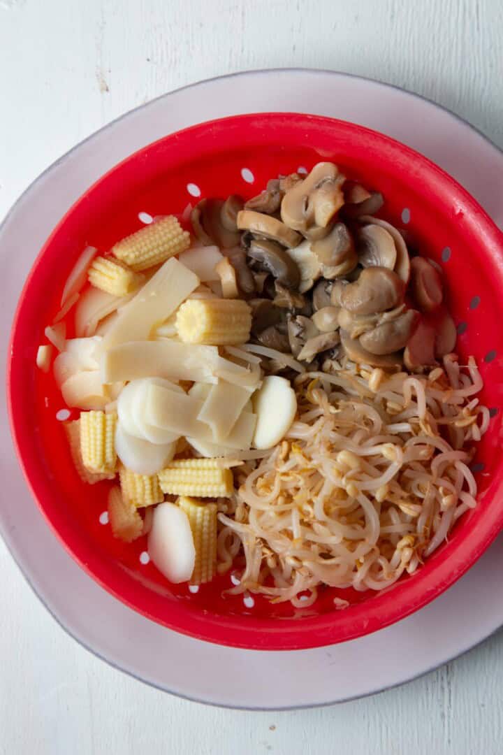colander filled with bean sprouts and mixed veggies.