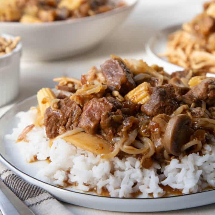 old fashioned chop suey on top of rice on a white plate.