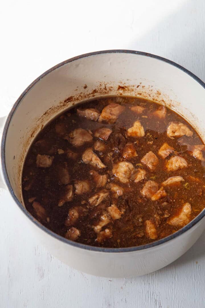cubes of meat in a dark brown sauce.