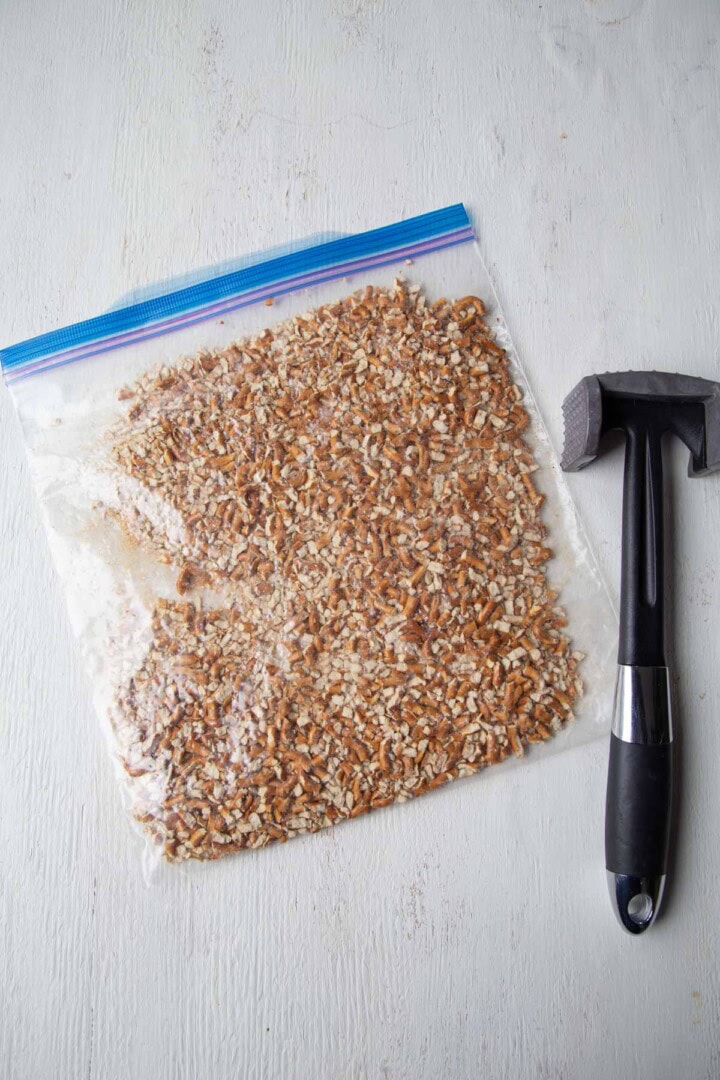 crushed pretzels in a zip top bag with a meat mallet.