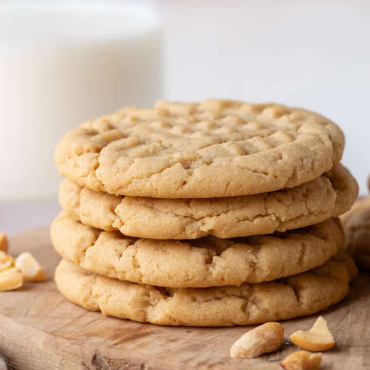 stack of peanut butter cookies on a wooden board.