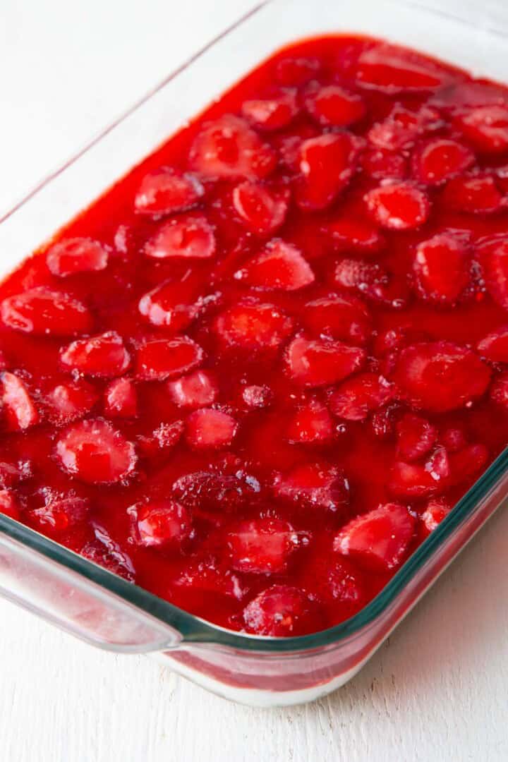 strawberry gelatin on top of a layered dessert.